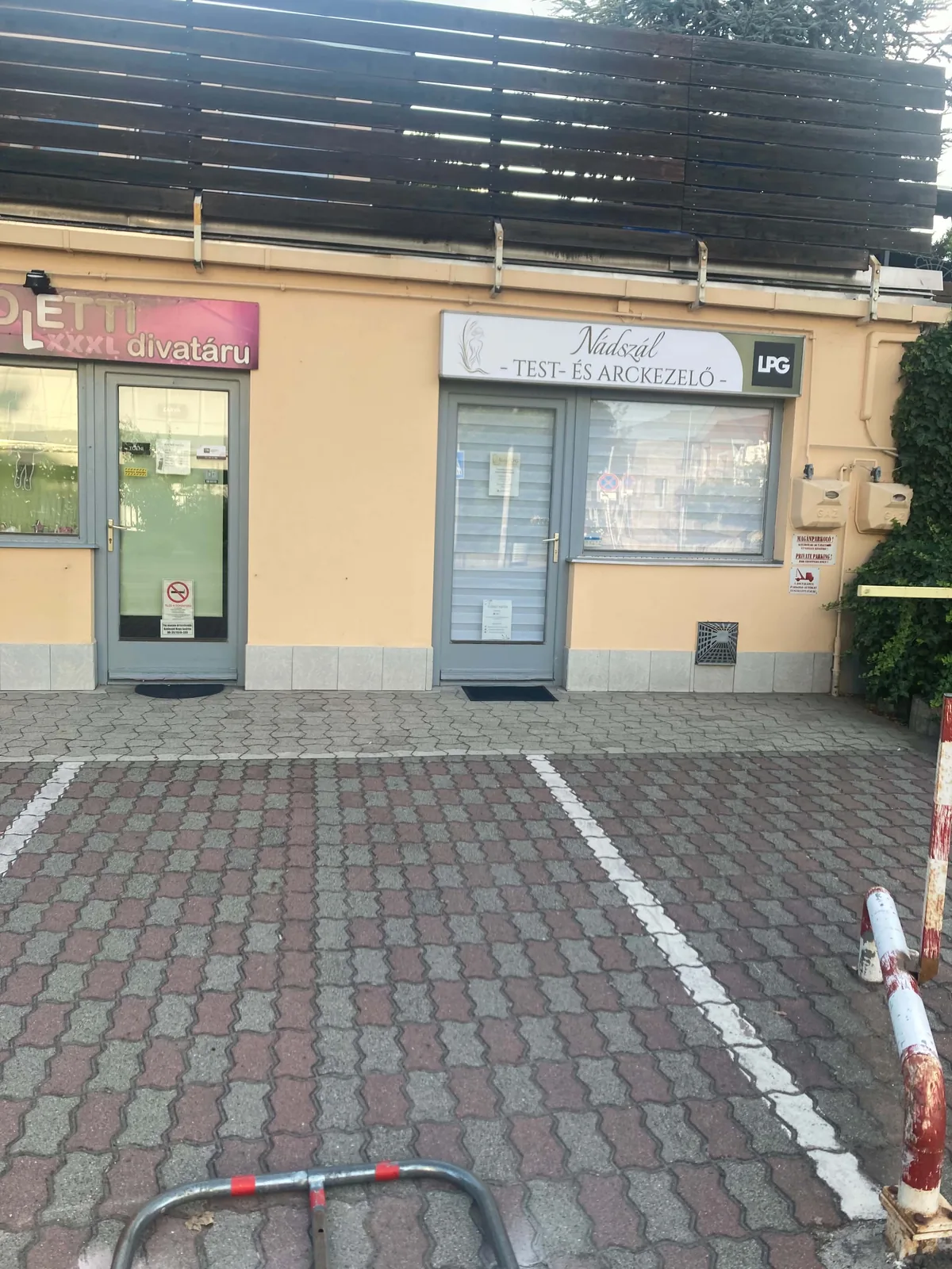 A Nádszál Test- és Arckezelő szalon bejárata a saját, jelzett parkolóhellyel a Jókai Mór utcában